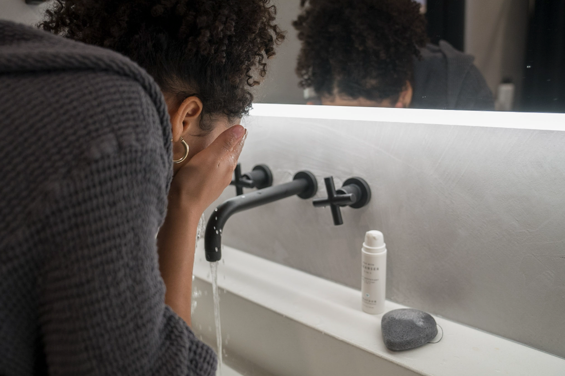 woman washing face with aloe milk and bamboo charcoal sponge